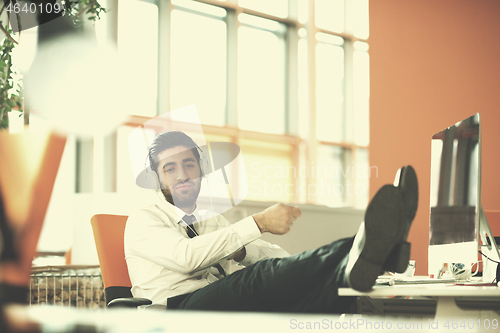 Image of relaxed young business man at office