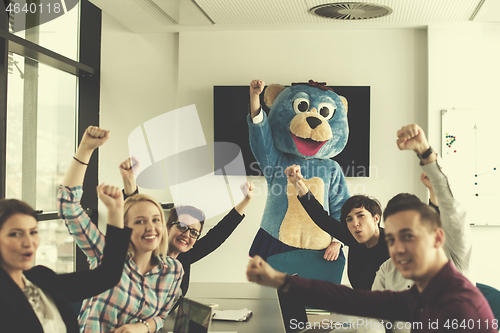 Image of boss dresed as bear having fun with business people in trendy of