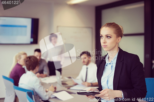 Image of business woman working on tablet at meeting room