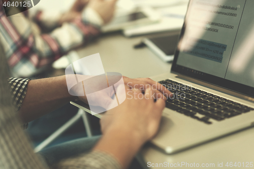 Image of close up of business man hands typing on laptop with team on mee