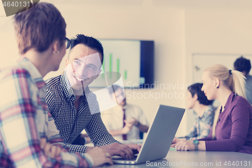 Image of young business couple working on laptop, businesspeople group on