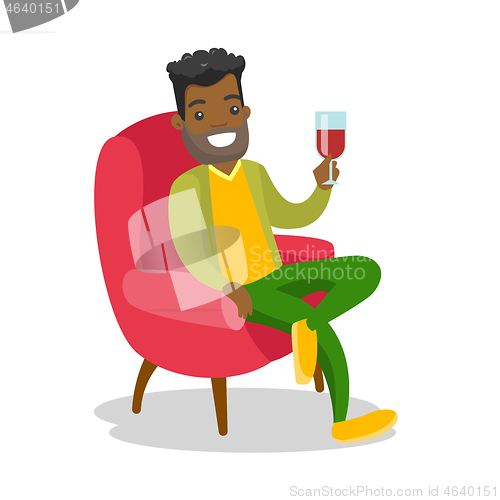 Image of African-american man drinking wine in the chair.