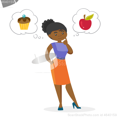 Image of African woman choosing between apple and cupcake.