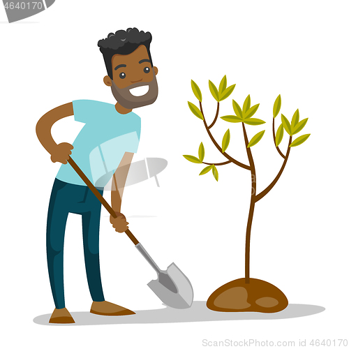 Image of Young african-american gardener plants a tree.
