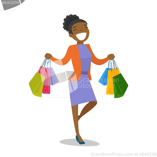Image of Young african-american woman holding shopping bags