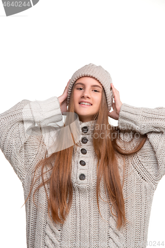 Image of portrait of cute little kid in stylish knitted sweater looking at camera and smiling