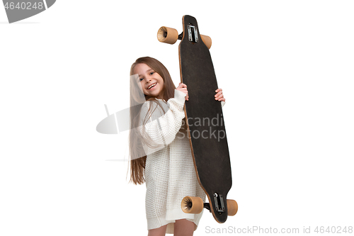 Image of portrait of an adorable young girl riding a skateboard isolated against white background