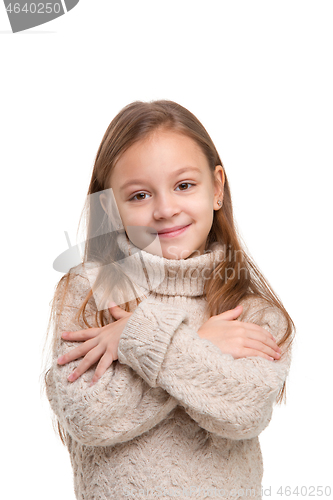 Image of portrait of cute little kid in stylish knitted sweater looking at camera and smiling