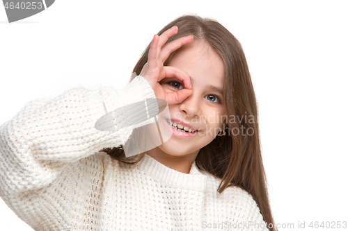 Image of portrait of cute little kid in stylish knitted sweater looking at camera and smiling