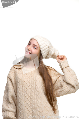 Image of portrait of cute little kid in stylish knitted sweater looking at camera and smiling