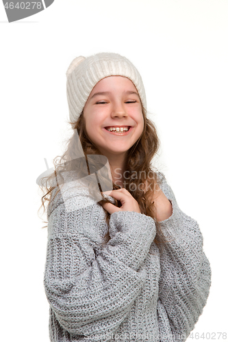 Image of portrait of cute little kid in stylish knitted sweater looking at camera and smiling