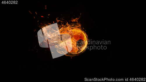Image of Close-up soccer ball in fire on dark background