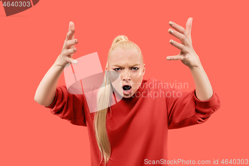 Image of Portrait of an angry woman looking at camera isolated on a coral background