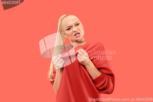 Image of Portrait of an angry woman looking at camera isolated on a coral background