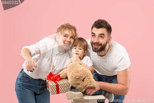 Image of happy family with kid together and smiling at camera isolated on pink