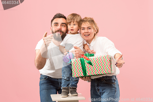 Image of happy family with kid together and smiling at camera isolated on pink