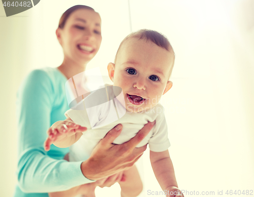 Image of happy young mother with little baby at home