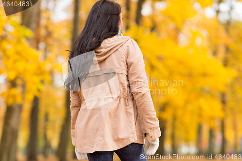 Image of young woman walking in autumn park