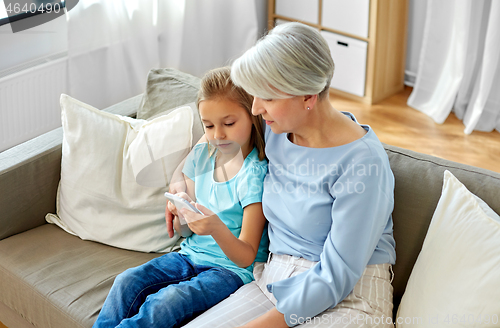 Image of grandmother and granddaughter with smartphone