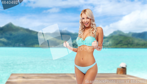 Image of happy young woman in bikini doing fist pump