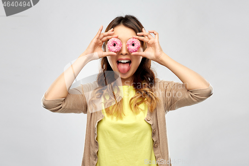 Image of asian woman with eyes of donuts showing tongue