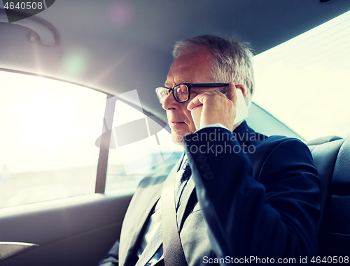 Image of senior businessman calling on smartphone in car