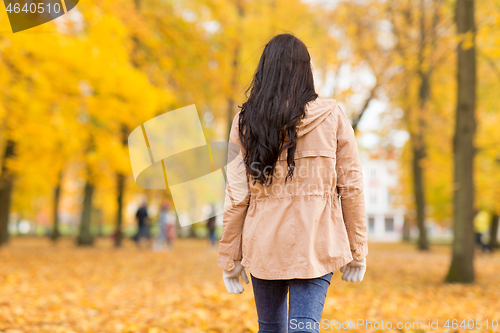 Image of young woman walking in autumn park