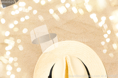 Image of straw hat on beach sand