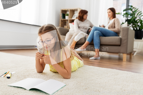 Image of student girl writing to notebook at home