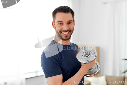 Image of man exercising with dumbbell at home