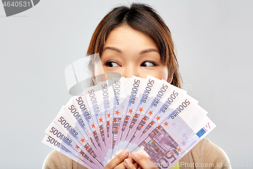 Image of asian woman with hundreds of euro money banknotes