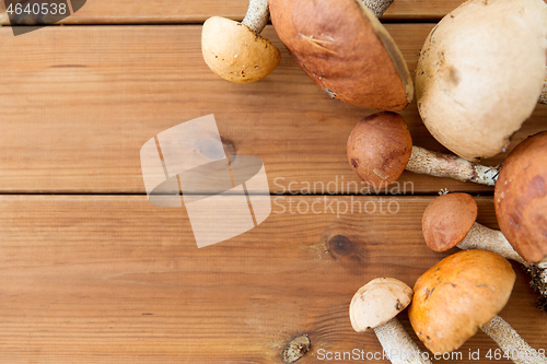 Image of brown cap boletus mushrooms on wooden background