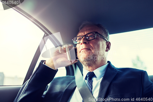 Image of senior businessman calling on smartphone in car