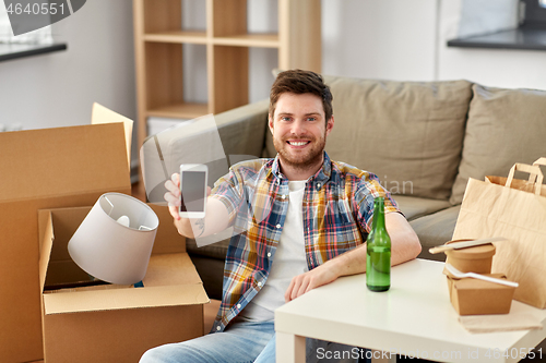 Image of man with smartphone and takeaway food moving