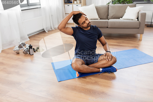 Image of man training and stretching body at home