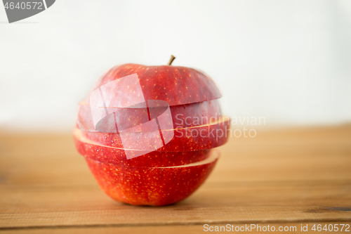 Image of sliced red apple on wooden table