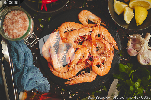 Image of Raw fresh prawns with various ingredients such as lemon fresh herbs, garlic, chilli pepper