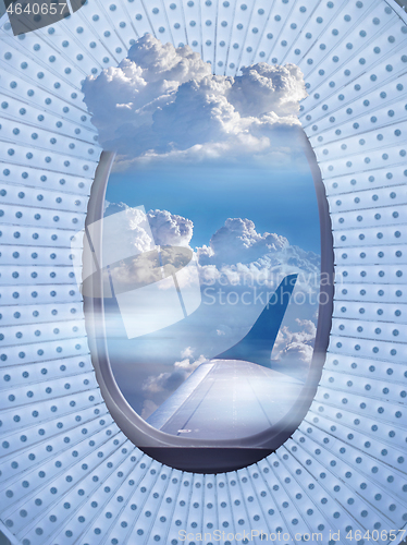 Image of Airplane window with picture of sky cloudy.