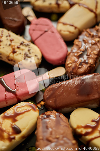 Image of Ice cream on stick coated with various chocolate glazes and toppings. Top view, flat lay