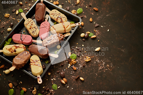 Image of Set of delicious white and milk chocolate and strawberry ice cream on a stick served in metal tray