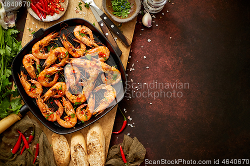 Image of Tasty appetizing roasted shrimps prawns with spices on pan with ingredients on rusty background