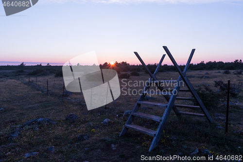 Image of Traditional wooden stile at a fence by sunset