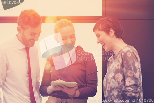 Image of young business people group working on tablet computer with sunr