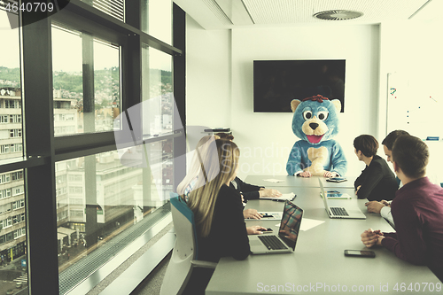 Image of boss dresed as bear having fun with business people in trendy of