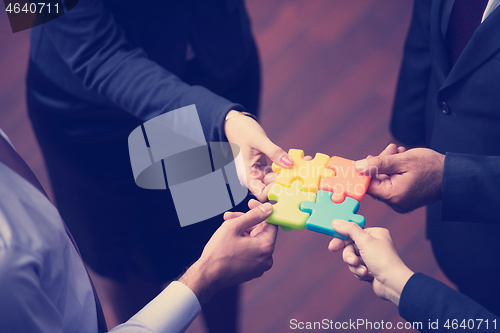 Image of top view of business people group assembling jigsaw puzzle