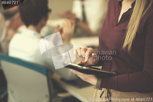 Image of blonde businesswoman working on tablet at office