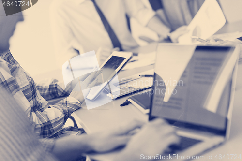 Image of close up of business man hands typing on laptop with team on mee