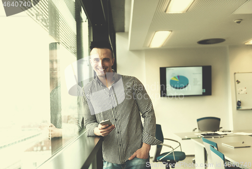 Image of young business man using smart phone at office