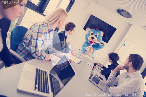 Image of boss dresed as bear having fun with business people in trendy of