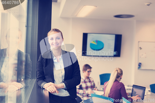 Image of portrait of young business woman at office with team on meeting 
